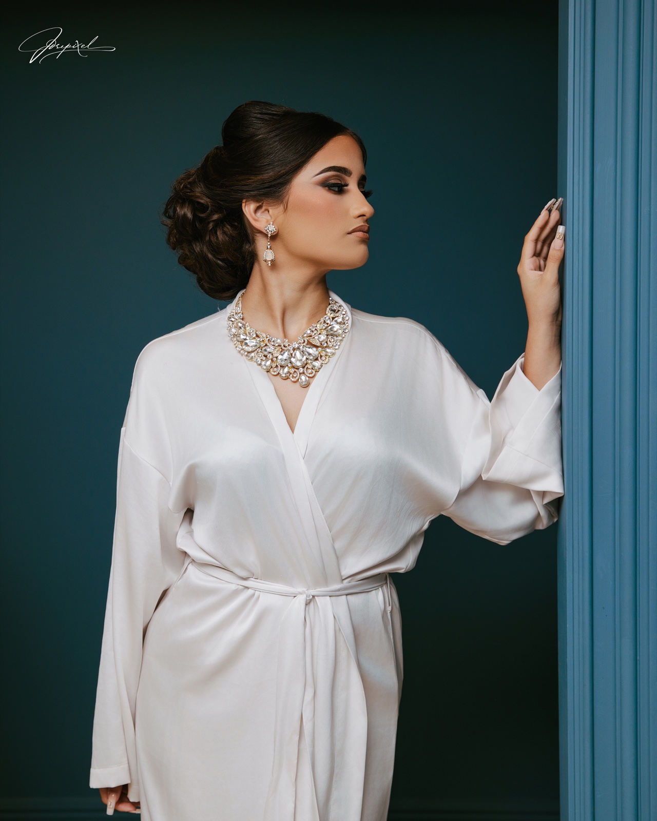 Quinceañera portrait in a white robe beside a teal doorway — Jose Pixels